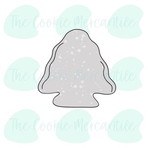 May include: A gray cookie cutter in the shape of a Christmas tree with white stars on it.