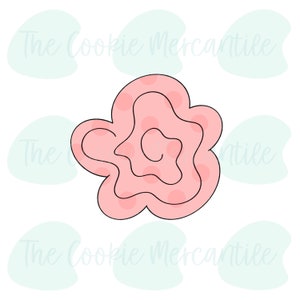 May include: A pink cookie cutter shaped like a flower with a swirl design. The cutter has a smooth, rounded edge.