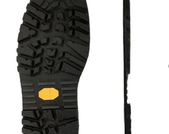 May include: Close-up view of the bottom of a black leather boot with a yellow rubber tread. The boot sole is designed for traction and grip.