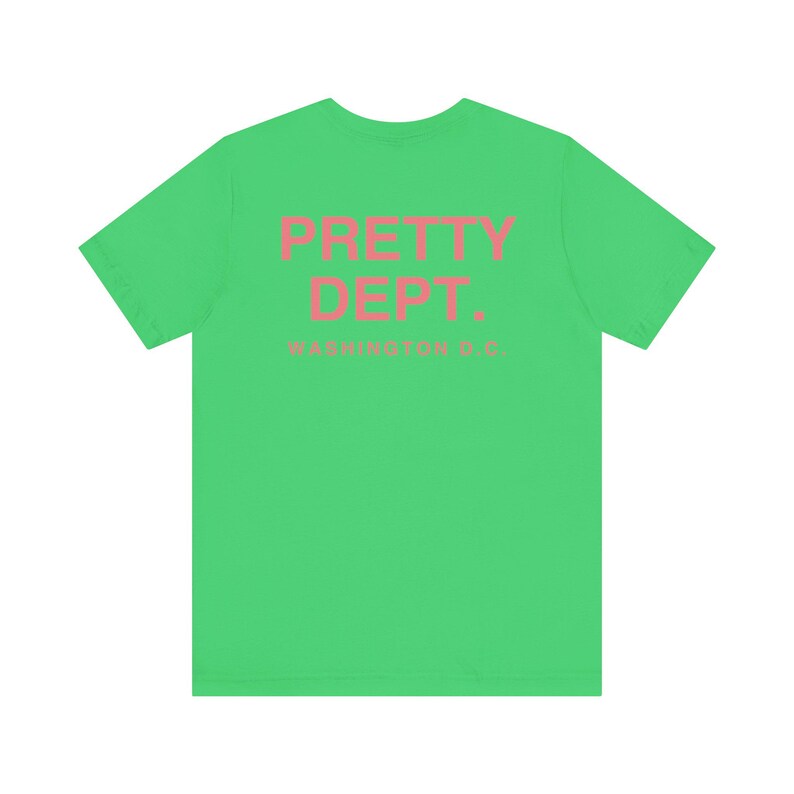 May include: A bright green t-shirt with the text "PRETTY DEPT." in pink, with "WASHINGTON D.C." below. The shirt is a solid color and has a crew neck.