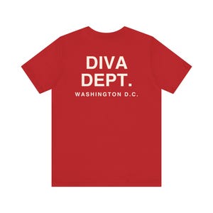 May include: A red t-shirt with the text "DIVA DEPT." and "WASHINGTON D.C." printed in white. The shirt is a short-sleeved crew neck style.