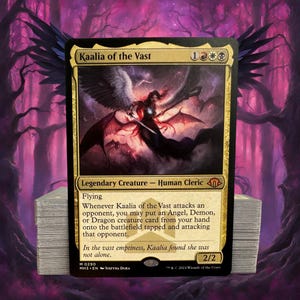 May include: A Magic: The Gathering card featuring Kaalia of the Vast, a Legendary Creature. The card has a gold and black border with an illustration of a winged figure wielding a sword. Text includes creature type, abilities, and flavor text.