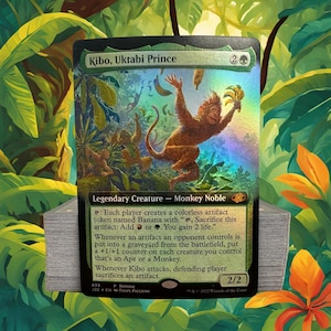 May include: A Magic: The Gathering card featuring Kibo, Uktabi Prince, a 2/2 legendary creature with green and black colors. The card art depicts a monkey holding a bunch of bananas, surrounded by other monkeys and a jungle background.