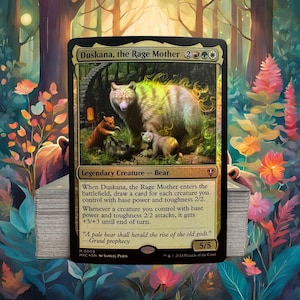 May include: A Magic: The Gathering card featuring "Duskana, the Rage Mother," a bear with two cubs, set in a forest scene. The card has a gold and black border with text describing the creature's abilities and the text "Gruul prophecy."