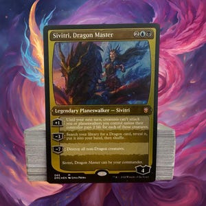 May include: A gold-bordered Magic: The Gathering card featuring Sivitri, Dragon Master. The card is a legendary planeswalker with a mana cost of 2 blue and 1 white. The card art depicts a woman riding a dragon.