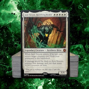 May include: A Magic: The Gathering card featuring Anti-Venom, Horrifying Healer. The card has a black border and a detailed illustration of a creature with green and black tones. Text includes "Legendary Creature - Symbiote Hero" and flavor text. A stack of cards is visible.