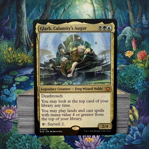 May include: A Magic: The Gathering card featuring "Glarb, Calamity's Augur," a frog wizard. The card has a gold border and depicts a frog character in a fantasy setting. The card text includes "Deathtouch" and other game instructions. A stack of cards is visible.