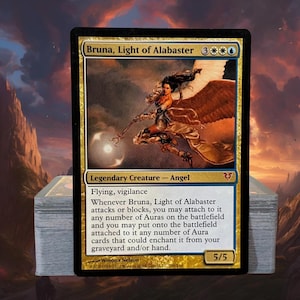 May include: A Magic: The Gathering trading card titled Bruna, Light of Alabaster, featuring a legendary angel creature with 5/5 power and toughness. The card displays artwork of a winged figure holding a staff, with text detailing game abilities.