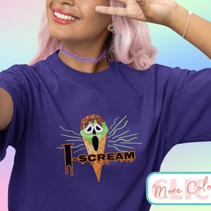 May include: Purple t-shirt with a green and brown ice cream cone graphic with a screaming face and the text "I Scream".