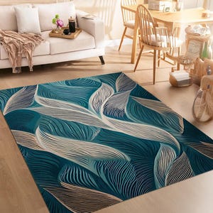 May include: A teal and cream abstract area rug with a swirling leaf pattern. The rug has a modern design and would add a touch of sophistication to any room.