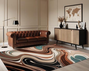 May include: A large area rug with a swirling abstract design in shades of brown, black, beige, and teal. The rug is placed on a hardwood floor in a living room setting, with a brown leather sofa and a wooden cabinet visible in the background.