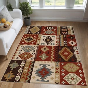 Può includere: Un tappeto multi-colore con un design sud-occidentale che presenta motivi geometrici in tonalità di rosso, marrone, beige e blu.