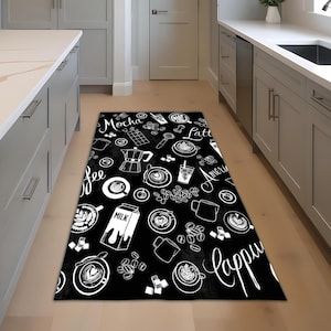 May include: Black rectangular kitchen rug with a white coffee-themed pattern. The design includes coffee cups, beans, a milk carton, and the words "Mocha," "Latte," "Americano," and "Cappuccino."