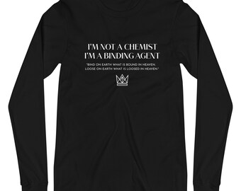 Könnte beinhalten: Schwarzes Langarm-T-Shirt mit weißem Text, der "I'M NOT A CHEMIST I'M A BINDING AGENT" lautet, und einem Zitat: "BIND ON EARTH WHAT IS BOUND IN HEAVEN. LOOSE ON EARTH WHAT IS LOOSED IN HEAVEN." Unter dem Zitat befindet sich eine stilisierte Krone.