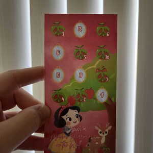 May include: A rectangular card featuring a Snow White theme. The card has a red background with illustrations of apples, mirrors, and a deer. Text on the card reads "Mirror Mirror on the Wall" and "Saves 90".