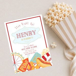 May include: A carnival-themed birthday invitation with a red border and the text "Step Right Up!" and "HENRY IS TURNING 5". The invitation includes illustrations of a Ferris wheel, hot dog, popcorn, and tickets. A container of popcorn is next to the invitation.