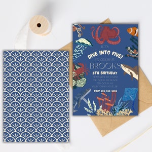 May include: A blue and white invitation with a nautical theme. The invitation reads "Let's Dive Into Five! To Celebrate Brooks 5th Birthday" with a date, time, and location. The invitation features a variety of sea creatures, including an octopus, a shark, a crab, a jellyfish, and a stingray.