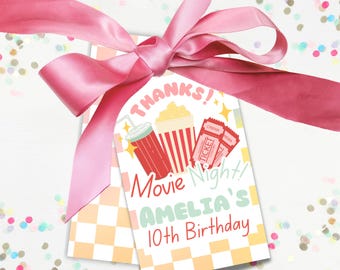 Op de afbeelding: Een roze en witte bedankkaart met een filmnacht thema. De kaart heeft een rood-wit gestreept popcornbakje, een rood-wit gestreept sodaglas en een filmticket. De tekst op de kaart luidt "Bedankt! Filmavond! Amelia's 10e verjaardag."