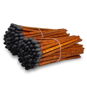 May include: Bundles of long wooden matches with black tips, tied together with clear bands. The matchsticks have a warm, reddish-brown color, creating a rustic aesthetic. The matches are arranged in two separate bundles, ready for use.