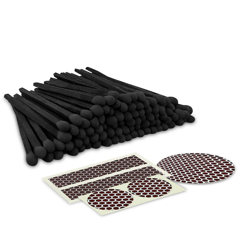 May include: A stack of 100 black matches with round black heads. The matches are arranged in a rectangular shape. There are three white stickers with brown honeycomb patterns.