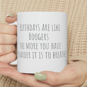 May include: White ceramic mug with black text that reads "Birthdays are like boogers. The more you have the harder it is to breathe!"