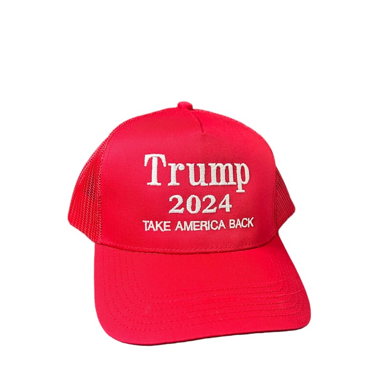 May include: Red mesh trucker hat with white embroidery that reads "Trump 2024 Take America Back."