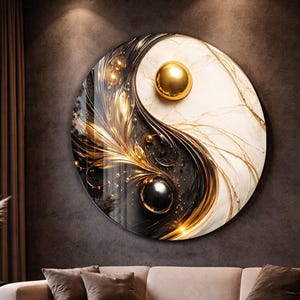 Peut inclure: Une grande œuvre d'art murale ronde représentant le symbole Yin et Yang. L'œuvre est divisée en sections noires et blanches, avec des accents dorés et des sphères. Elle est accrochée à un mur gris foncé au-dessus d'un canapé beige, créant une esthétique moderne.