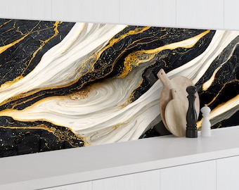 May include: Black and white marble kitchen splashback with gold accents. The splashback is behind a white countertop with wooden chopping boards and salt and pepper shakers.