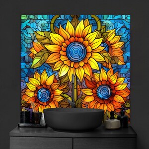 May include: A stained glass style design featuring three sunflowers with yellow petals and brown centers. The sunflowers are set against a blue and green background with a mosaic pattern.