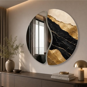 May include: A circular wall mirror featuring a split design. One half is a clear reflective glass surface, while the other half displays an abstract pattern of black marble textures accented with textured gold and cream-colored paint layers.
