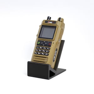 May include: Tan handheld radio with a black display screen, buttons, and keypad. The radio is labeled "VR-N76" and is mounted on a black stand. The radio has the brand name "OVSEC" on the top.