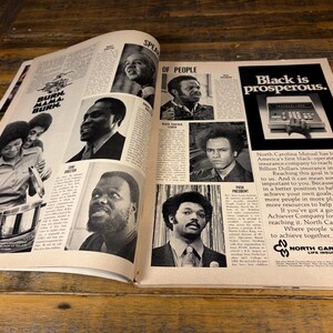 K&ouml;nnte beinhalten: Eine Doppelseite einer Zeitschrift mit Schwarz-Wei&szlig;-Bildern und Text. Der Text enth&auml;lt "BURN MAMA BURN" und "Black is prosperous." Das Magazin zeigt auch Portr&auml;ts mehrerer Schwarzer und eine Werbung f&uuml;r North Carolina Mutual.