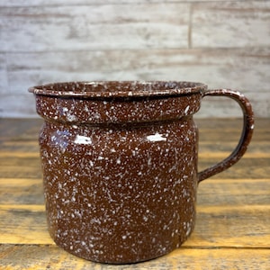 Puede incluir: Una taza de cerámica blanca con un asa negra y el texto "But First, Coffee" en un estilo manuscrito. La taza es para bebidas calientes y tiene un acabado brillante.