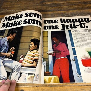 K&ouml;nnte beinhalten: Eine Vintage-Zeitschriftenwerbung f&uuml;r Jell-O. Die Anzeige zeigt drei Personen, eine mit einem Getr&auml;nk, eine andere sitzend und eine dritte mit einem Teller. Der Text lautet "Make some one happy. one Jell-O."