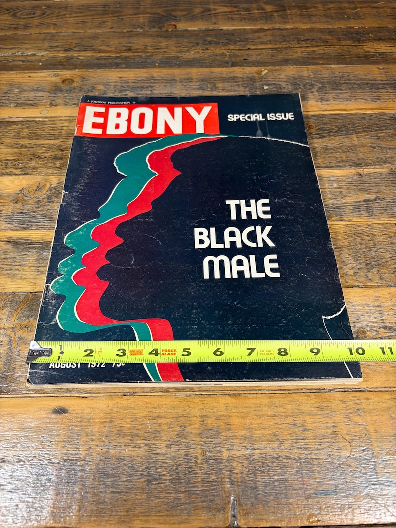 K&ouml;nnte beinhalten: Eine Augustausgabe 1972 des Ebony-Magazins. Das Cover zeigt das Logo der Zeitschrift in Rot und Wei&szlig; mit den Worten "Special Issue" &uuml;ber dem Titel. Der Titel "The Black Male" steht in wei&szlig;er Schrift auf schwarzem Hintergrund.