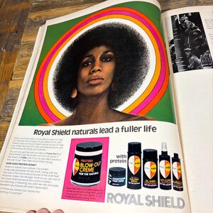 K&ouml;nnte beinhalten: Vintage-Werbung f&uuml;r Royal Shield Haarprodukte. Die Anzeige zeigt eine Frau mit einer gro&szlig;en Afro-Frisur, umrahmt von einem farbenfrohen kreisf&ouml;rmigen Design. Verschiedene Haarpflegeprodukte werden gezeigt, darunter Protein Blow-Out Creme und Holding Spray.