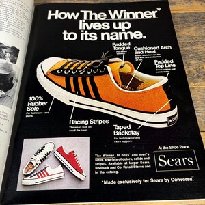 K&ouml;nnte beinhalten: Werbung f&uuml;r Sears-Sneaker. Das Hauptbild zeigt einen orangefarbenen und schwarzen Sneaker mit wei&szlig;en Sohlen und Rennstreifen. Der Text hebt Merkmale wie die gepolsterte Zunge und das gepolsterte Fu&szlig;gew&ouml;lbe hervor. Zus&auml;tzliche Sneaker in Rot und Wei&szlig; sind ebenfalls abgebildet.