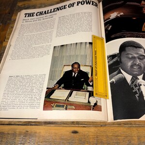 K&ouml;nnte beinhalten: Eine aufgeschlagene Magazinseite mit der &Uuml;berschrift "THE CHALLENGE OF POWER" und Text &uuml;ber Schwarze M&auml;nner in Afrika und Amerika. Ein gelbes Lineal liegt auf der Seite. Bilder von schwarzen M&auml;nnern sind zu sehen.