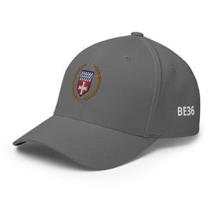 Könnte beinhalten: Eine graue Baseballkappe mit einem gestickten Wappen, das ein Schild mit einem Kreuz und einem Lorbeerkranz zeigt. Der Text "BE36" ist auf der Rückseite der Kappe gestickt.