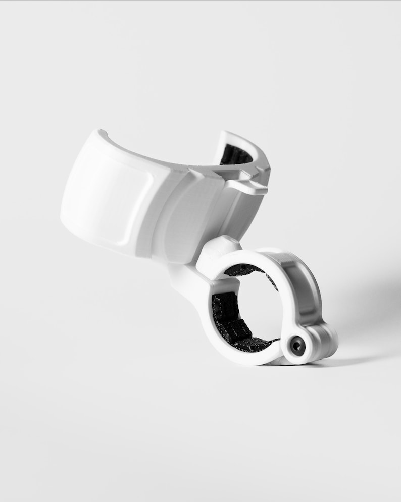 A professionally shot GO Plus + compatible handlebar mount, rugged edition, in gloss white. This angled product shot on a white background highlights the curved snap-fit cradle and the secure circular clamp at the base. The durable mounting accessory is designed to hold a circular mobile gaming auto-catcher on handlebars for bikes, scooters, and strollers, providing a stable, hands-free solution for active players.