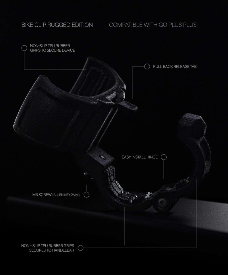 Infographic of the Bike Clip Rugged Edition, a Go plus + compatible handlebar mount, against a black background. Labels highlight key features: non-slip TPU rubber grips for both the device and handlebar, a pull-back release tab, and an easy install hinge with an M3 screw. The matte-black, carbon fiber infused 3D printed accessory is designed to securely hold a circular mobile gaming auto-catcher on bikes or scooters, offering a durable, hands-free mounting solution for active players.