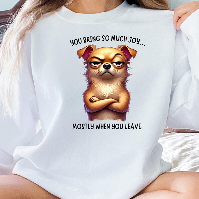 May include: White sweatshirt with a cartoon image of a brown dog with a grumpy expression. The text "You bring so much joy... mostly when you leave." is printed on the sweatshirt.