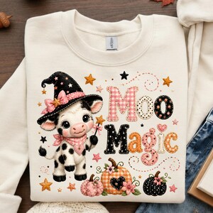 May include: Cream sweatshirt with a cartoon cow in a witch's hat and wand. The text "Moo Magic" is displayed with decorative lettering, stars, and pumpkins. A whimsical design, perfect for autumn or Halloween.