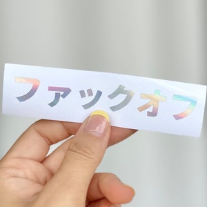 May include: A white sticker with the Japanese text "ファックオフ" in iridescent rainbow letters.