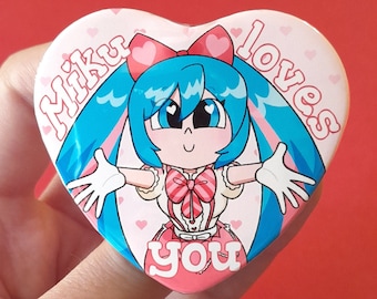 May include: A pink heart-shaped button with a cartoon character with blue hair and a pink bow. The text "Miku loves you" is printed on the button.