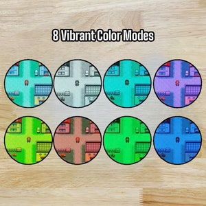 Puede incluir: Ocho variaciones de color diferentes de una escena de ciudad pixelada. La escena muestra un coche peque&ntilde;o conduciendo por una calle con edificios a ambos lados. Los colores incluyen verde, azul, morado, rojo, gris y turquesa.