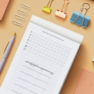 May include: A white notebook with lined paper and the text "Edwardian Script Lowercase Font" at the top. The notebook has several lines of lowercase letters written in cursive, including the alphabet and the word "abcdefghijklmnopqrstuvwxyz".