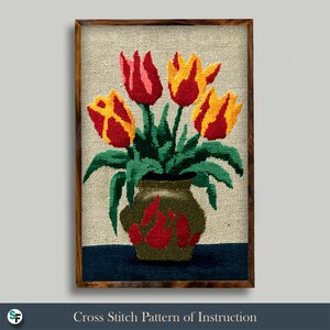 Puede incluir: Un patrón de punto de cruz enmarcado con un jarrón de tulipanes. Los tulipanes son rojos y amarillos, con hojas verdes. El jarrón es de color verde oliva con detalles en rojo. El marco es de madera oscura. El texto "Cross Stitch Pattern of Instruction" está en la parte inferior.