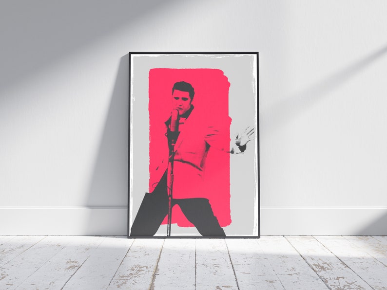 May include: A black and white image of a man singing into a microphone. The man is wearing a suit and is standing in front of a bright pink background.