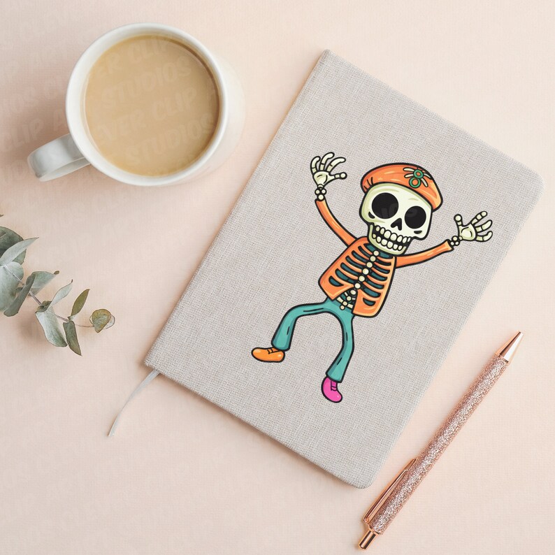 Puede incluir: Una libreta beige con un esqueleto de dibujos animados colorido que lleva un sombrero y pantalones vaqueros azules. La libreta tiene una cuerda blanca atada a ella y un bol&iacute;grafo dorado est&aacute; acostado a su lado.